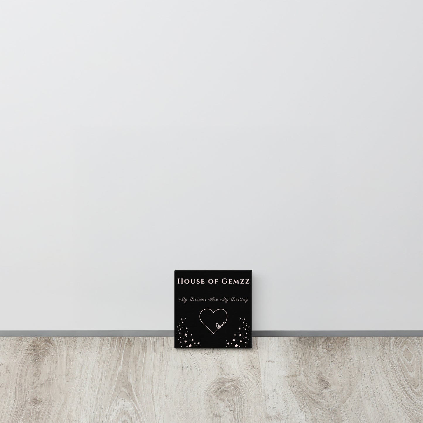 Black card with 'House of Gemzz' text and heart design on a white wall.