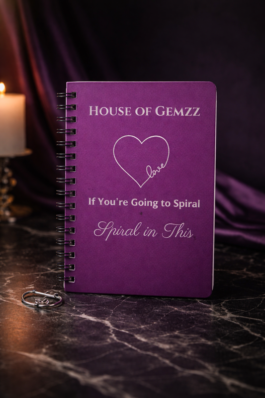 Purple notebook with 'House of Gemzz' text on a dark surface
